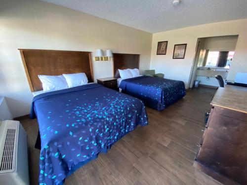 Habitación de hotel con 2 camas con sábanas azules en Coral Roc Motel, en Florida City
