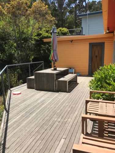 a deck with an umbrella and a frisbee at Otway Blue in Wye River
