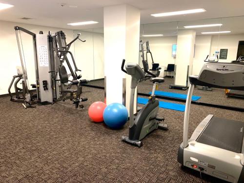 a gym with treadmills and exercise bikes and balls at Corporate Living Accommodation Abbotsford in Melbourne