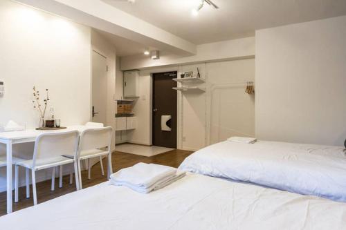 een slaapkamer met een bed en een tafel en stoelen bij Dwell Urban 2B in Tokyo