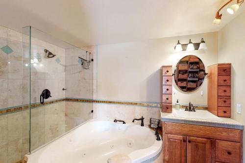 a bathroom with a tub and a glass shower at Jarvis #303 in Durango