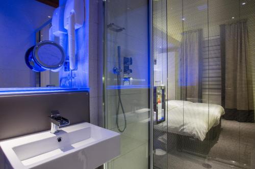 a bathroom with a sink and a glass shower at Henley House Hotel in London