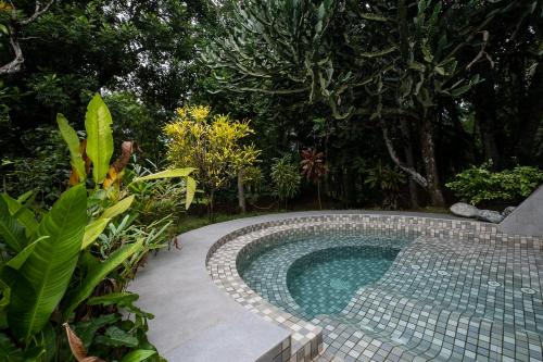 a small swimming pool in the middle of a garden at Horathapola Estate in Marawila