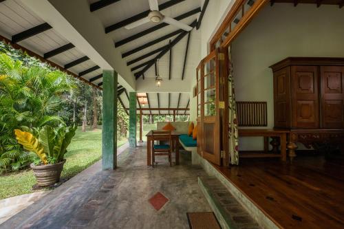 a porch of a house with a table and a chair at Horathapola Estate in Marawila