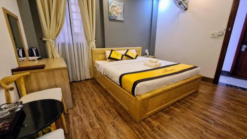 a bedroom with a bed with a yellow and white sheets at Hoàng Gia Hotel Côn Đảo in Con Dao