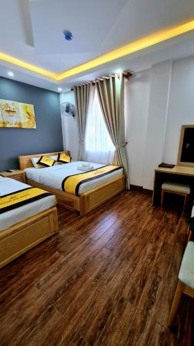 a bedroom with two beds and a window at Hoàng Gia Hotel Côn Đảo in Con Dao