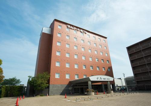 a hotel building with orange cones in front of it at Moriyama Art Hotel in Moriyama