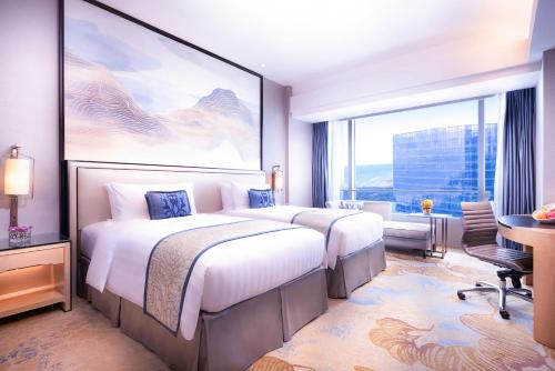 Postel nebo postele na pokoji v ubytování Shangri-La Xiamen