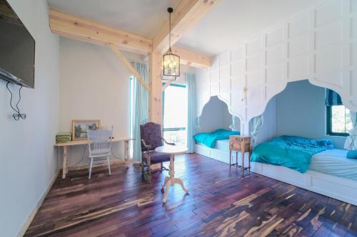 a bedroom with two beds and a desk and a table at Lacasa May in Da Lat