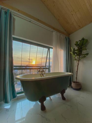 a bath tub in a room with a large window at Lacasa May in Da Lat