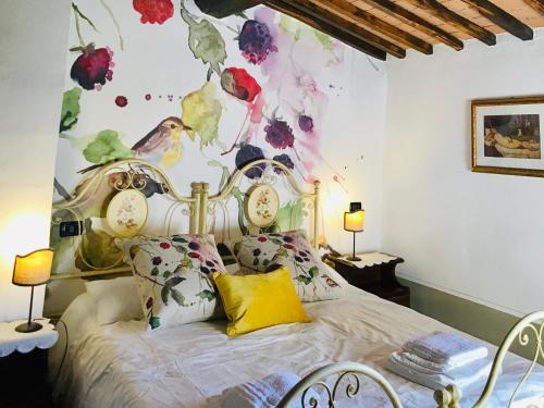 ein Schlafzimmer mit einem Bett mit Uhren an der Wand in der Unterkunft Borgo Fastelli - House in historical Borgo in Tuscany - Quercia in Spineta