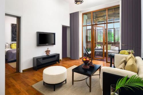 a living room with a couch and a tv at The Lake Garden Hotel Nay Pyi Taw - MGallery Collection in Nay Pyi Taw