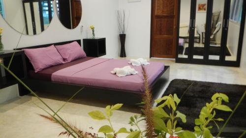 a room with a purple couch with towels on it at Monkey Flower Villas in Koh Tao