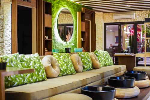 un sofá largo en una habitación con espejo en FuramaXclusive Ocean Beach Seminyak Bali en Legian