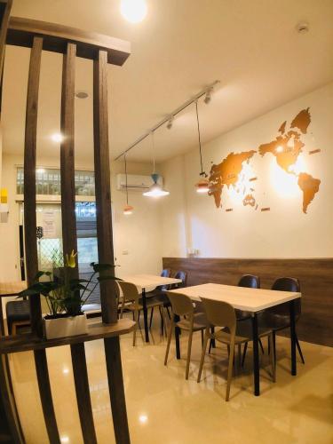 a restaurant with tables and chairs and a world map on the wall at 910 Hostel (Chengdong) in Yuli