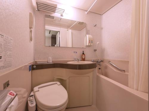 a small bathroom with a toilet and a sink at Ariston Hotel Miyazaki in Miyazaki