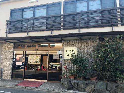 een gebouw met ramen en planten ervoor bij Takigawa Ryokan in Kyoto
