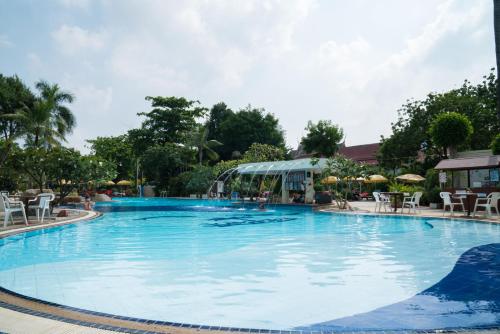 una gran piscina en un complejo con sillas y sombrillas en Grand Jomtien Palace Hotel - SHA Extra Plus, en Jomtien Beach