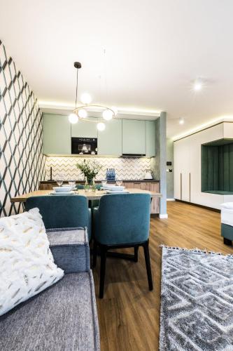 a kitchen and living room with a table and chairs at Rezydencja Zakopiańska in Zakopane