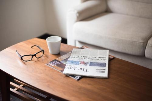 a coffee table with a newspaper and glasses on it at the b nagoya in Nagoya