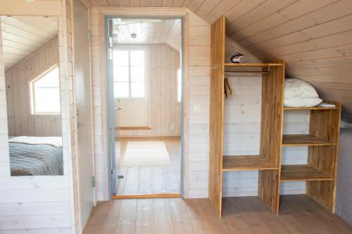 a tiny house with a bedroom and a bunk bed at Everts Sjöbods Bed & Breakfast in Grebbestad