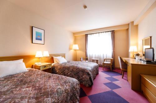 Postel nebo postele na pokoji v ubytování Fukuno Town Hotel A・Mieux