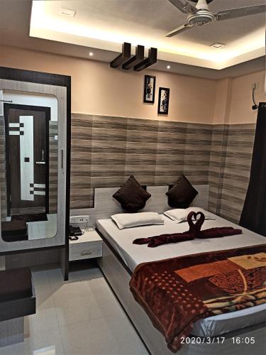 a bedroom with a large bed and a mirror at Hotel Prince B in Guwahati