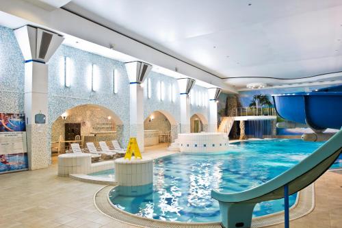 a swimming pool in a building with a slide at Health Resort Volzhskie Dali in Pristannoye