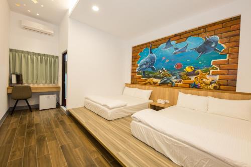 ein Schlafzimmer mit 2 Betten und einem Wandgemälde in der Unterkunft Xiaoliuqiu 88 Homestay in Xiaoliuqiu