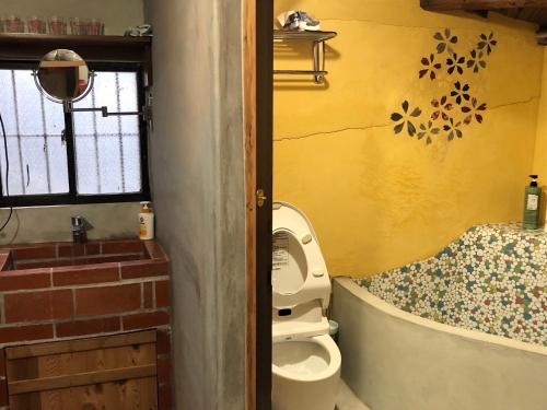 a small bathroom with a toilet and a window at Jiufen Xiaomei Meow Seaview Homestay in Jiufen