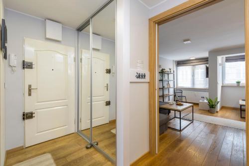 a bathroom with a sliding glass door and a hallway at oompH Wroclaw Old Town Apartment in Wrocław