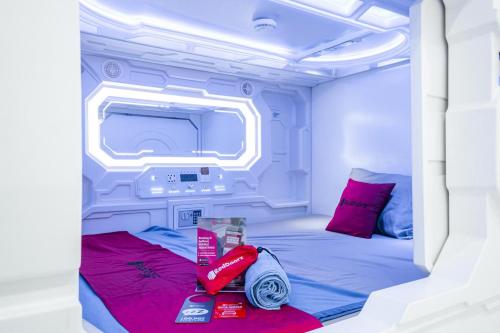 a small room with a bed and a tv at RedDoorz Hostel near Taman Puring in Jakarta