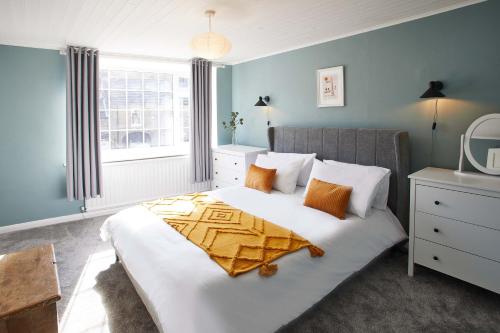 - une chambre avec un grand lit blanc aux murs bleus dans l'établissement Host & Stay - The Snug, à Skelton