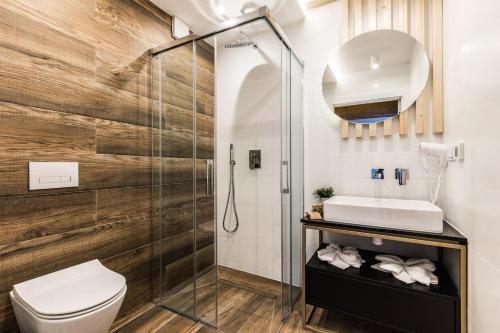 a bathroom with a shower and a toilet and a sink at Rezydencja Zakopiańska in Zakopane