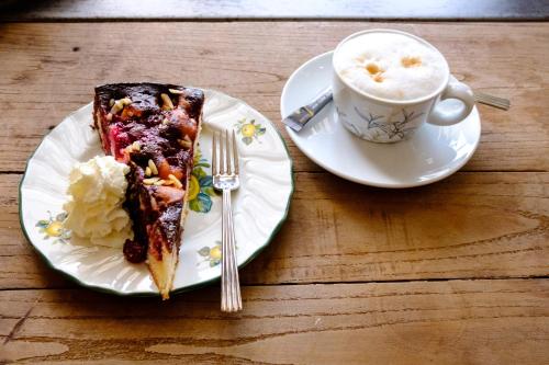 a piece of cake on a plate next to a cup of coffee at The Starnbergsee Hideaway in Seeshaupt
