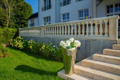 a vase of flowers sitting on the steps of a house at The Starnbergsee Hideaway in Seeshaupt