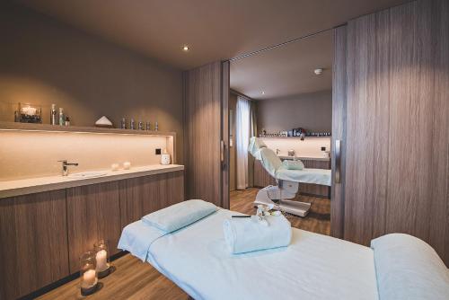 Habitación hospitalaria con 2 camas y espejo en Art Boutique Hotel Monopol, en St. Moritz