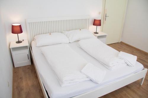 - un lit blanc avec des draps et des oreillers blancs dans l'établissement Vienna4you App 10 you are welcome, à Vienne