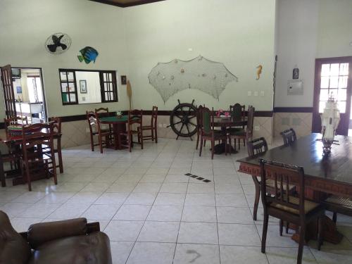a dining room with tables and chairs and a large room at Pousada Albamar Guarujá in Guarujá