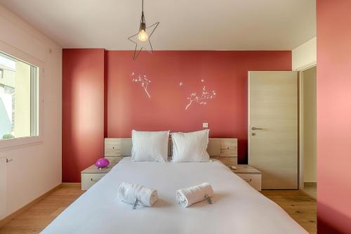 1 dormitorio con 1 cama blanca grande y paredes rojas en Appart L'avant Scene Tresums, en Annecy