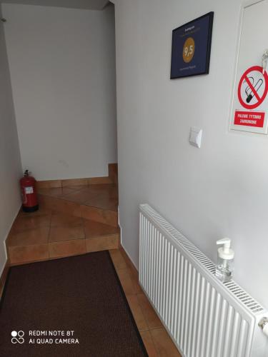 a hallway with a staircase with a sign on the wall at Apartamenty Wygoda Białystok in Białystok
