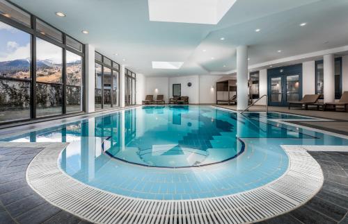 uma piscina com água azul num edifício em Anett hotel em Vipiteno