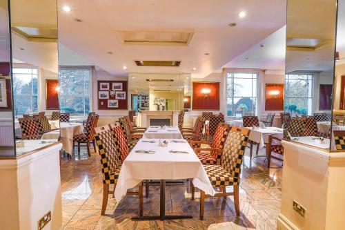 レミントン・スパにあるThe Jephson Hotel; BW Signature Collectionの部屋にテーブルと椅子があるレストラン