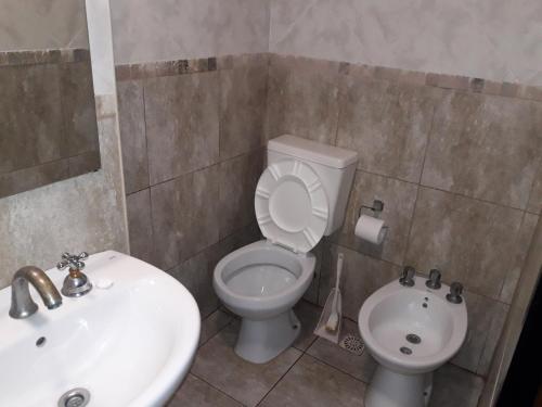 ein Badezimmer mit einem weißen WC und einem Waschbecken in der Unterkunft CABAÑAS VILLA CLUB 2 cerca de aeropuerto El Palomar in Hurlingham