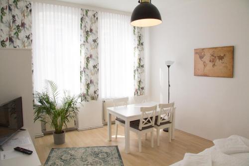 een witte eettafel en stoelen in een kamer bij Vienna4you App 20 you are welcome in Wenen