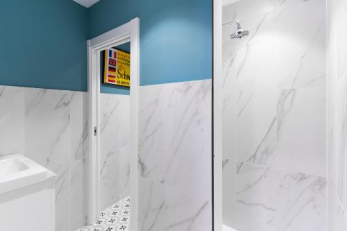 a white bathroom with a shower and a sink at Housingleón - Albergue Turístico Nama Hostel in León