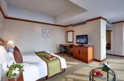 a hotel room with a bed and a desk at Baiyoke Sky Hotel in Bangkok