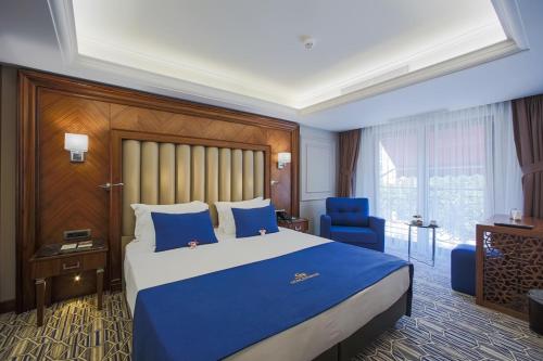 Habitación de hotel con cama azul y silla azul en Gonluferah City Hotel en Bursa