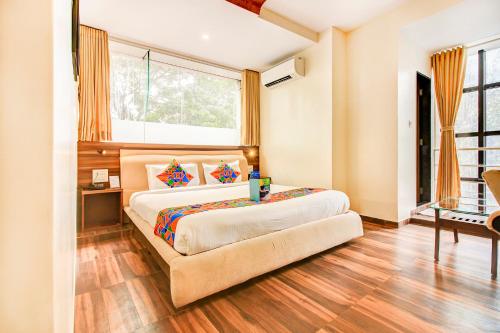 a bedroom with a large bed and a window at FabHotel Axis International in Mumbai