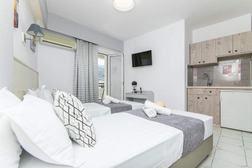 a bedroom with two beds and a kitchen at ICandy Sol in Malia